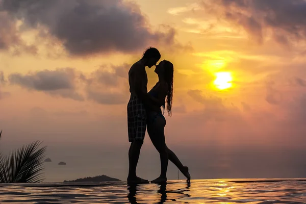 Silhouette of a woman and men on the panoramic swimming pool at sunset — Stock Photo, Image