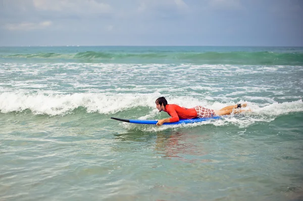 Mann im Neoprenanzug mit Surfbrett am Strand — Stockfoto