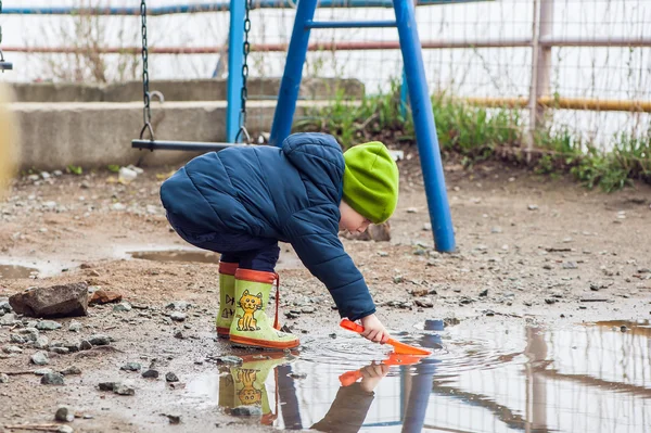 Toddler boy jumping in the puddles — Stock Photo, Image