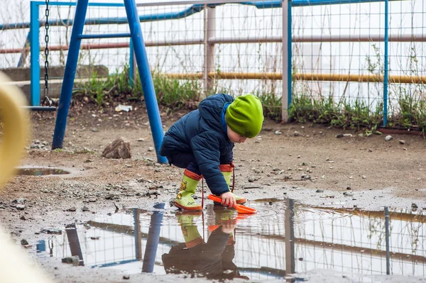 Toddler boy jumping in the puddles — Stock Photo, Image