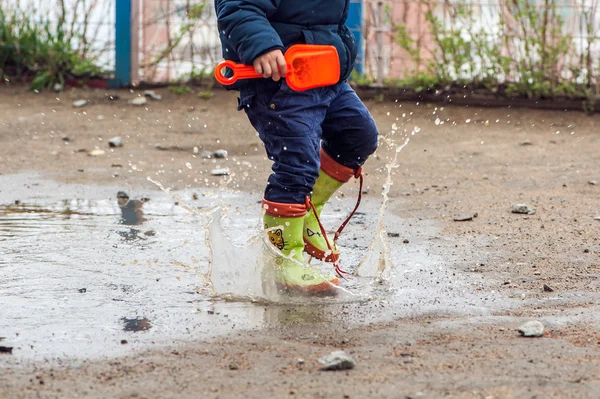 Toddler boy jumping in the puddles — Stock Photo, Image