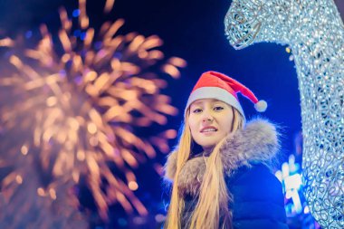 Genç bir kadın Noel 'i kutluyor ve havai fişekleri izliyor. Çılgın 2020 bitti, 2021 'deyiz.