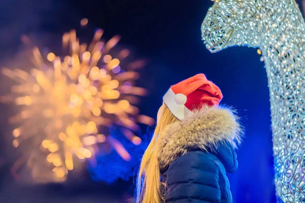 Junge Frau feiert Weihnachten und sieht Weihnachtsfeuerwerk. Verrücktes 2020 ist vorbei, sein 2021 — Stockfoto