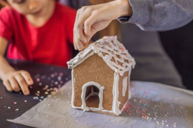 Genç anne ve çocuk Noel arifesinde zencefilli kurabiye yapıyorlar.