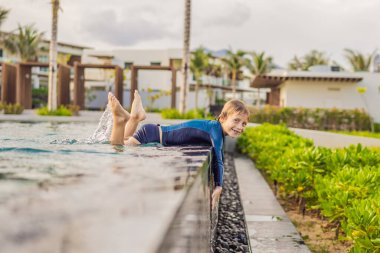 Yüzme havuzunun mavi sularındaki küçük şirin çocuk, yaz tatili eğlence için.