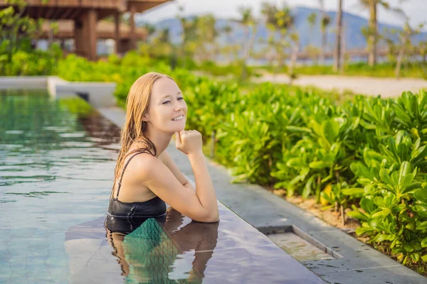 Donna rilassante in piscina a sfioro guardando la vista — Foto Stock