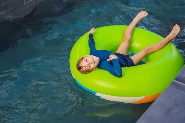 Küçük çocuk eğlence merkezinde lastik halkayla yüzüyor. — Stok fotoğraf