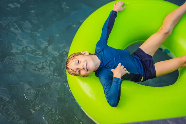 Мальчик плавает с резиновым кольцом в развлекательном центре — стоковое фото