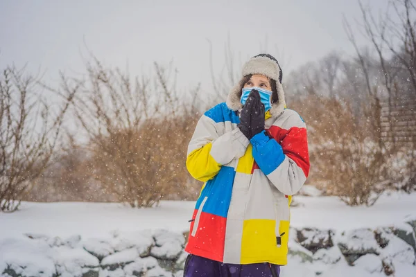 男はCOVID-19コロナウイルスのために医療用マスクを着用雪の下で冬に非常に凍結されました。冬の問題 — ストック写真