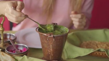 Kafkasyalı genç bir kadın restoranda Hint yemeklerine eşlik ediyor. Hint yemeği konsepti