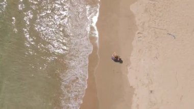 Güzel bir plajda koşan genç bir kadının yavaş çekim görüntüsü. Sağlıklı yaşam tarzı ve spor anlayışı