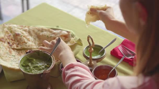 Młoda, kaukaska kobieta delektująca się indyjskim jedzeniem w restauracji. Koncepcja żywności indyjskiej — Wideo stockowe