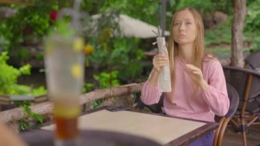 Bir kafede, genç bir kadın kendi kullanılabilir metal pipetini getirdiği için tek kullanımlık plastik pipet almayı reddediyor. Tek plastiğin kullanımını azaltma kavramı