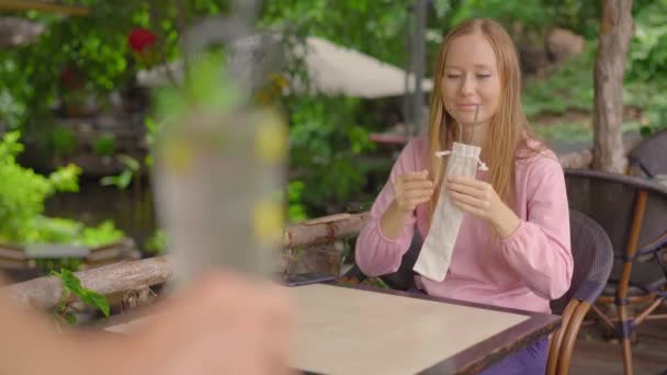 In einem Café weigert sich eine junge Frau, einen Einweg-Trinkhalm aus Plastik zu nehmen, weil sie ihre eigenen wiederverwendbaren Metallhalme mitgebracht hat. Konzept zur Verringerung der Verwendung von Einzelplastik — Stockvideo