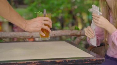 Yakın plan çekim. Bir kafede, genç bir kadın tek kullanımlık plastik pipet yerine kendi kullanılabilir metal pipetini kullanıyor. Tek plastiğin kullanımını azaltma kavramı