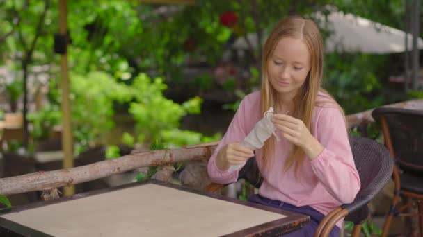 In einem Café verwendet eine junge Frau statt eines Einweg-Trinkhalms aus Plastik ihre eigenen wiederverwendbaren Metallhalme. Konzept zur Verringerung der Verwendung von Einzelplastik — Stockvideo