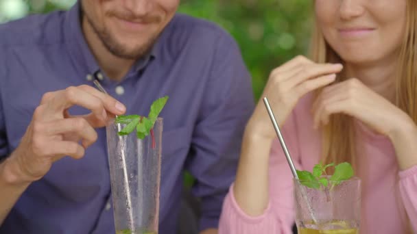 In un bar giovane coppia hanno una chiacchierata. Bevono le loro bevande usando cannucce d'acciaio reusabla. Concetto di ridurre l'uso di plastica singola — Video Stock