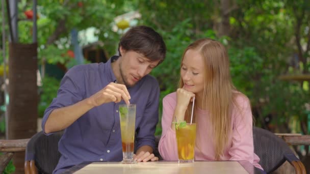 カフェで若いカップルのチャットがあります。彼らは再利用可能な鋼の藁を使用して彼らの飲み物を飲む。使い捨てプラスチックの削減というコンセプト — ストック動画