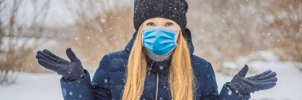 La donna che indossava una maschera medica durante il COVID-19 coronavirus era molto congelata in inverno sotto la nevicata. Indossare maschere mediche in inverno BANNER, FORMATO LUNGO — Foto Stock