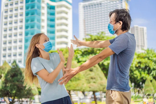 Concept de distance sociale. Un homme veut saluer avec un câlin, mais une femme maintient une distance sociale — Photo