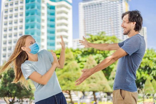 Concept de distance sociale. Un homme veut saluer avec un câlin, mais une femme maintient une distance sociale — Photo