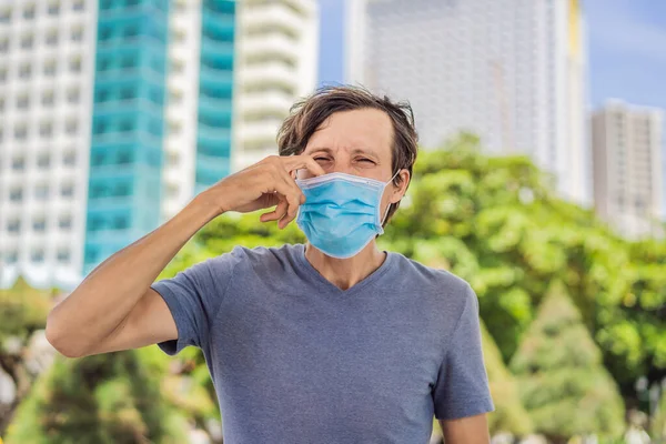 Improper wearing of mask concept. Man scratching his nose under the mask, touches the mask — Stock Photo, Image