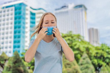 Uygunsuz maske takmak. Maskenin altında burnunu kaşıyan kadın maskeye dokunuyor.