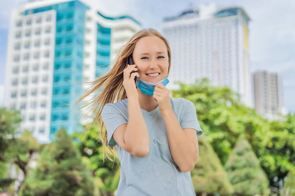 Maszk koncepció helytelen viselése. A maszkos nő rosszul öltözött, levette a maszkot, miközben telefonált. — Stock Fotó