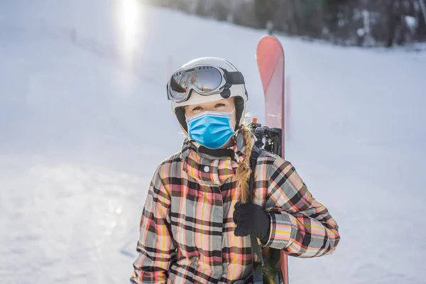 Žena snowboardista nosit lékařskou masku během COVID-19 coronavirus na slunném zimním dni v lyžařském středisku — Stock fotografie