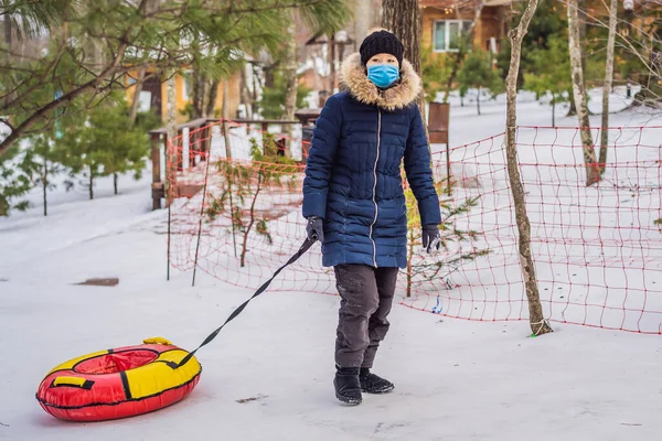 Inverno, svago, sport, amicizia e concetto di persone: donne e tubi da neve indossano una maschera medica durante il COVID-19 coronavirus — Foto Stock