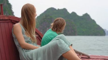Anne ve oğul turistler binlerce küçük ve büyük kireçtaşı adasından oluşan Vietnam 'daki Halong Körfezi Ulusal Parkı' nı ziyaret ediyorlar. Vietnam 'a seyahat