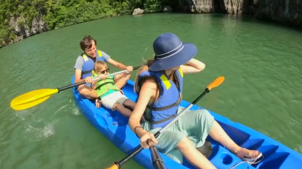 Lassított felvétel egy boldog turista családról, akik a mészkő sziklák között kajakoznak egy Halong Bay-i nemzeti parkban, Vietnamban. Utazás Vietnam koncepció — Stock videók