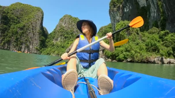 Slowmotion skott av en lycklig familj av turister kajak bland kalksten klippor i en Halong Bay nationalpark, Vietnam. Resa till Vietnam konceptet — Stockvideo