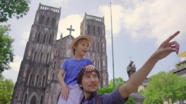 Mutlu turistlerin babası ve oğlu Hanoi şehrindeki ünlü varış yeri olan St. Josephs Katedrali 'ni ziyaret ediyor. Vietnam 'a seyahat