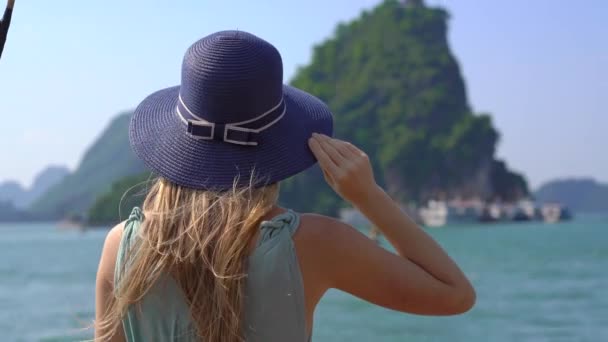 Egy fiatal nő turista ellátogat a Halong Bay Nemzeti Parkba Vietnamban, amely több ezer kis és nagy mészkő szigetből áll. Utazás Vietnam koncepció — Stock videók
