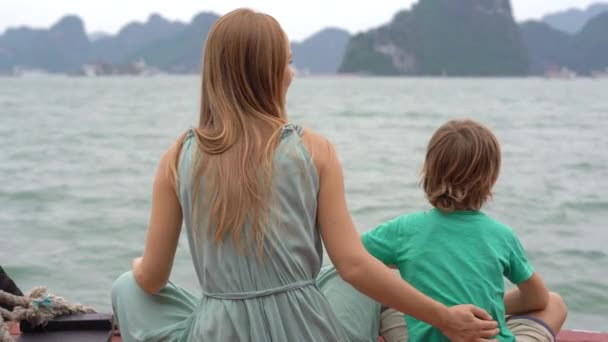 Los turistas de madre e hijo visitan el parque nacional de Halong Bay en Vietnam que consta de miles de pequeñas y grandes islas de piedra caliza. Viajar a Vietnam concepto — Vídeos de Stock