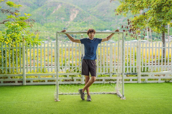 Un entrenador de fútbol para niños se para en un gol de fútbol infantil — Foto de Stock