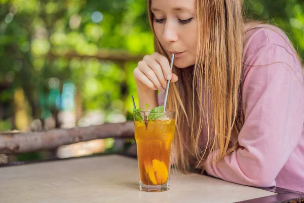 Экологически дружелюбная женщина, использующая многоразовую стальную соломинку для питья фруктового чая — стоковое фото