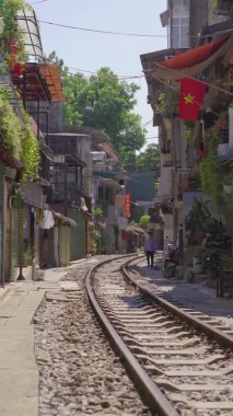 22.10.2020 - HANOI, VİETNAM: Dikey video. Hanoi şehrindeki bir yerleşim alanından geçen demiryolu. Hanoi Tren Sokağı ünlü bir turizm merkezidir.