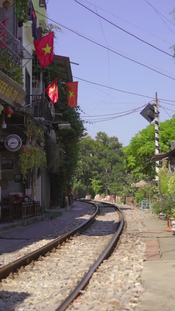 22.10.2020 - HANOI, VIETNAM: Verticale video. De spoorlijn die door een woonwijk in Hanoi stad gaat. Hanoi Train Street is een beroemde toeristische bestemming — Stockvideo