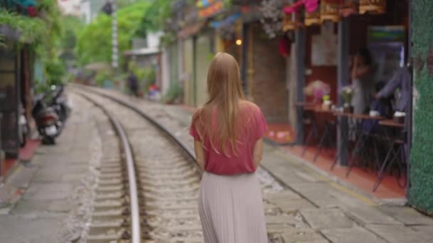 年轻的女旅行家探索河内市的一个地区，那里的铁路路线穿过住宅区。河内火车站街是一个有名的旅游胜地 — 图库视频影像
