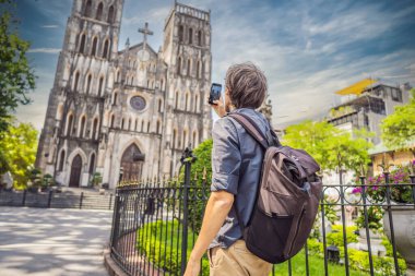 Hanoi 'deki Aziz Josephs Katedrali' nin arka planındaki genç turist. Vietnam, koronavirüs karantinası COVID 19 'dan sonra yeniden açıldı.