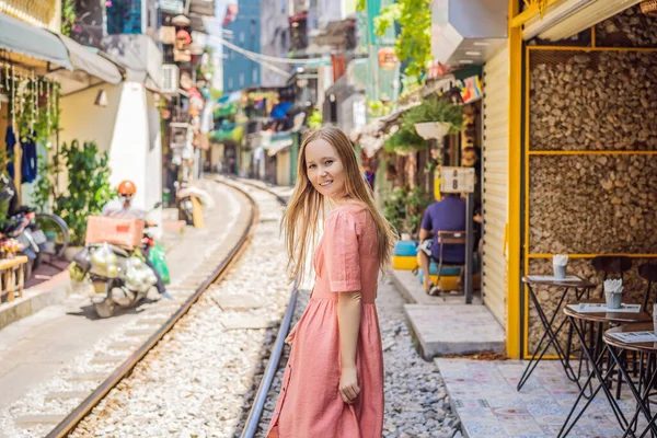 Kvinnan promenerar på Hanois stadsjärnväg. Perspektiv utsikt löper längs smal gata med hus i Vietnam. Hanoi tåggata, gammalt hus och järnväg. Vietnam återupptas efter karantänen för coronavirus — Stockfoto