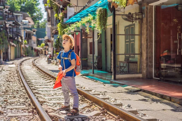 Rapaz viajante caminhar em torno de caminhos de ferro que passam por área residencial na cidade de Hanói. Hanoi Train Street é um destino turístico famoso. Vietname reabre após quarentena com coronavírus COVID 19 — Fotografia de Stock