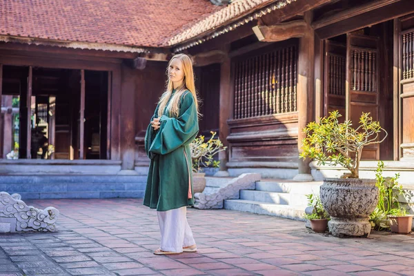 Touristin in vietnamesischer Nationaltracht im Literaturtempel in Hanoi in Südostasien, Vietnam. Vietnam öffnet nach Coronavirus-Quarantäne COVID 19 wieder — Stockfoto