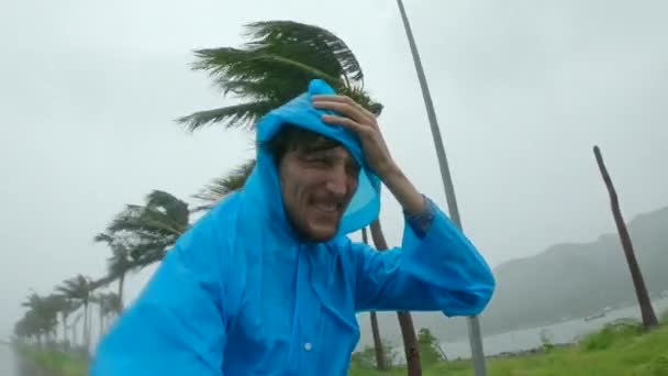 A man in a raincoat is under a hevy rain and stormy wind. Shot on an action camera. Tropical storm concept. Contains natural sound — Stock Video