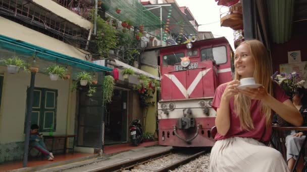 22.10.2020 - HANOI, VIETNAM: Slow-motion shot van een jonge vrouwelijke reiziger verkent het gebied van de stad Hanoi waar spoorwegpaden door een woonwijk lopen. Hanoi Train Street is een beroemde toerist — Stockvideo