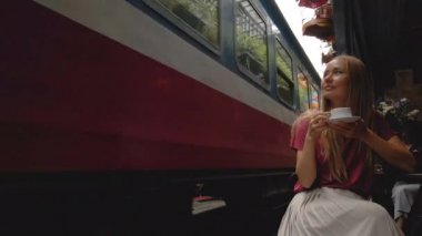 22.10.2020 - HANOI, VIETNAM: Hanoi şehrinde demiryolunun yerleşim alanından geçtiği alanı yavaş çekim yapan genç bir kadın gezgin. Hanoi Tren Sokağı ünlü bir turisttir.