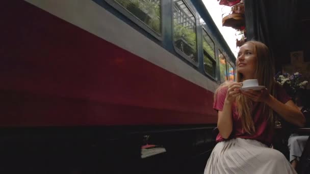 22.10.2020 - HANOI, VIETNAM: Slow-motion shot of a young woman traveler explores the area of the Hanoi city where railway paths go through a residential area. Hanoi Train Street is a famous tourist — Wideo stockowe