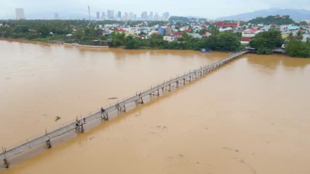 Luchtfoto van een houten brug over de rivier in Azië met motoren erop. Concept voor gevaarlijke vervoersconstructies — Stockvideo